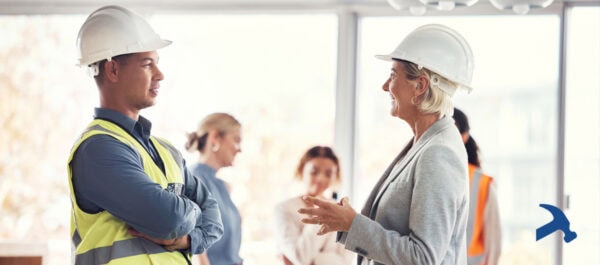 Talking to and vetting a construction contractor - a woman in a hard hat and a man in a hard hat and hi-vis fest talking